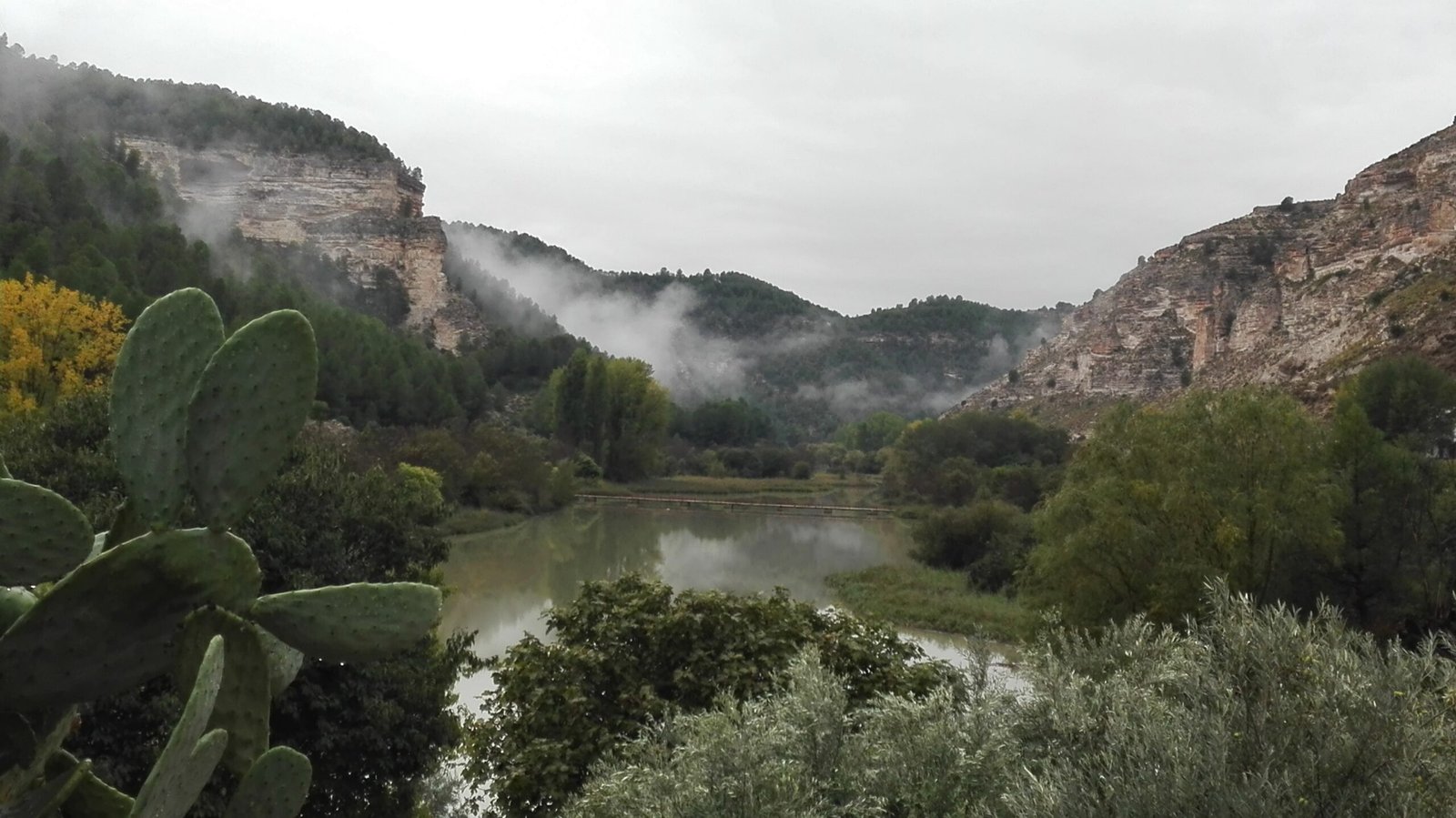 Paisaje otoñal del río Júcar entre montañas y niebla en Alcalá del Júcar